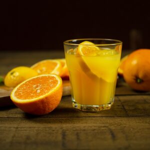 orange juice in clear drinking glass